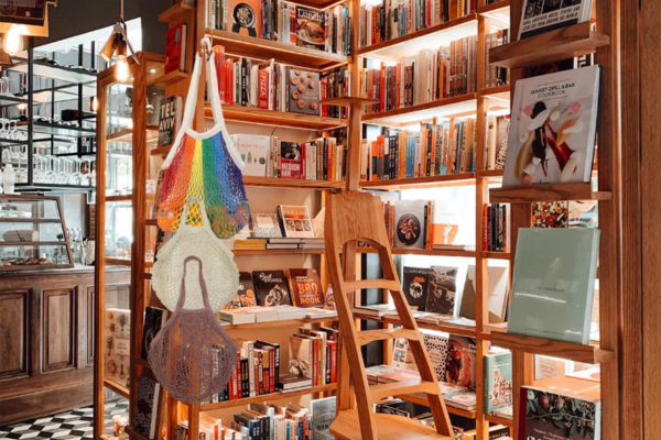 Bookshelf filled with books and decorative items in a cozy bookstore setting.