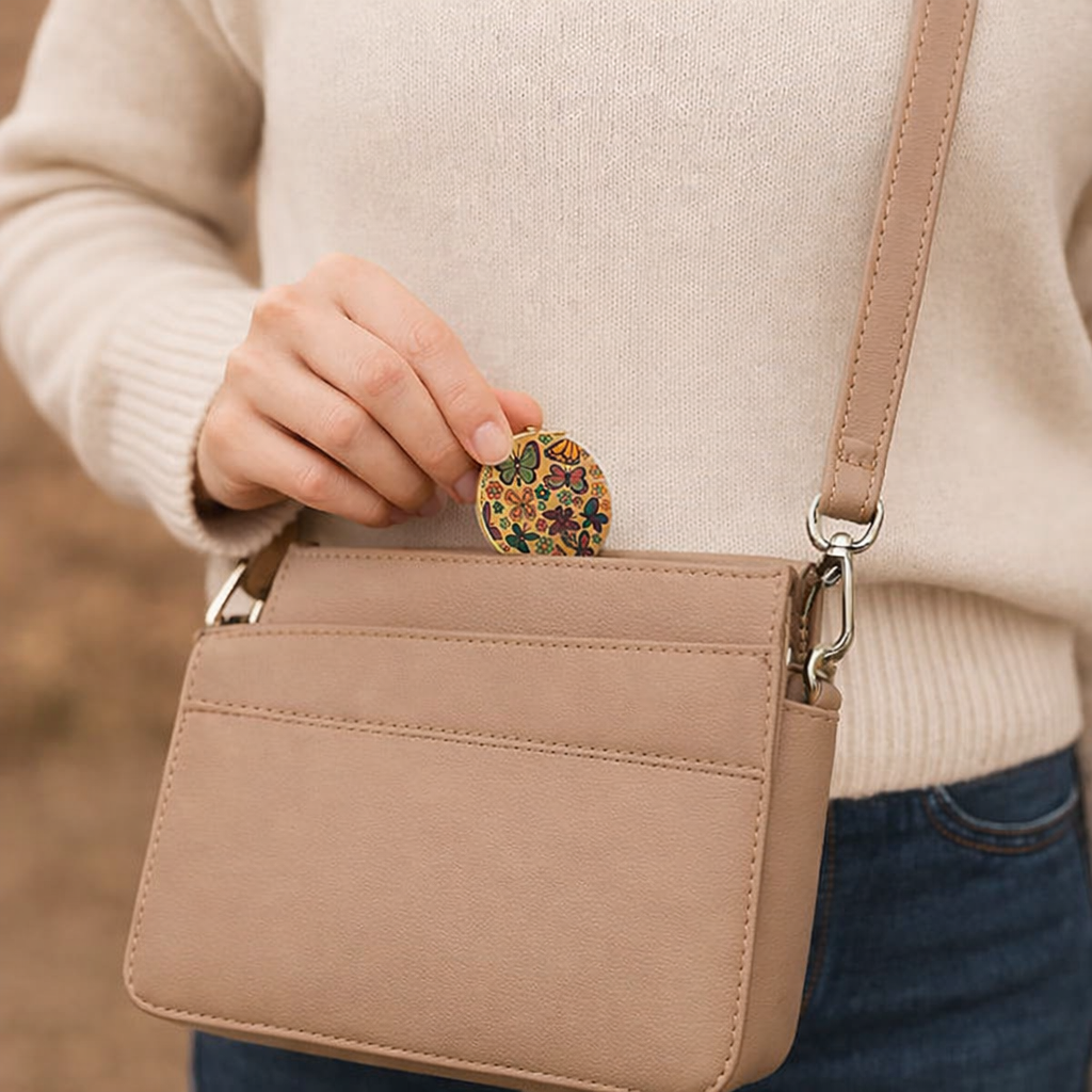 Butterfly cork mirror IRENE being inserted into handbag by woman