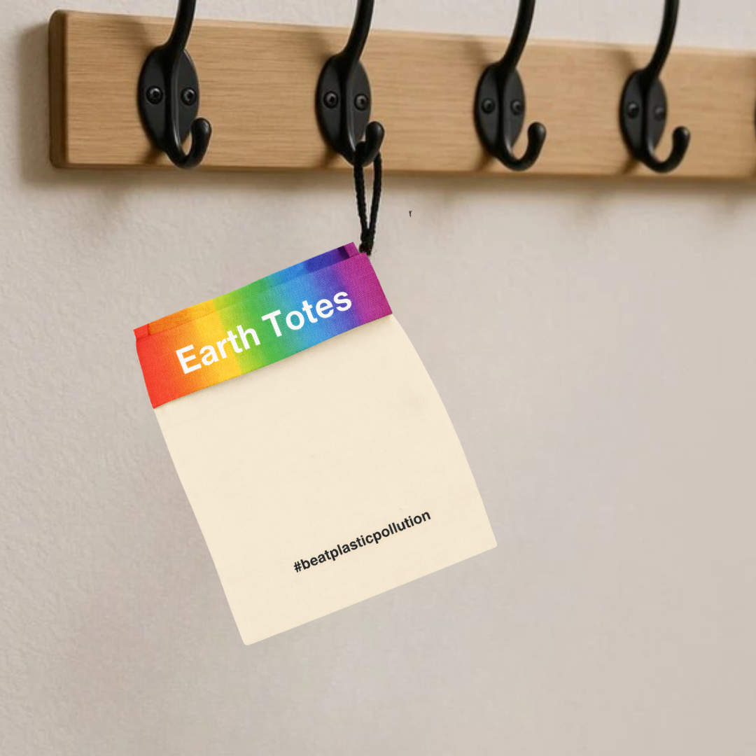 Colorful tag with 'Earth Totes' and '#beatplasticpollution' text hanging on a wooden hook.